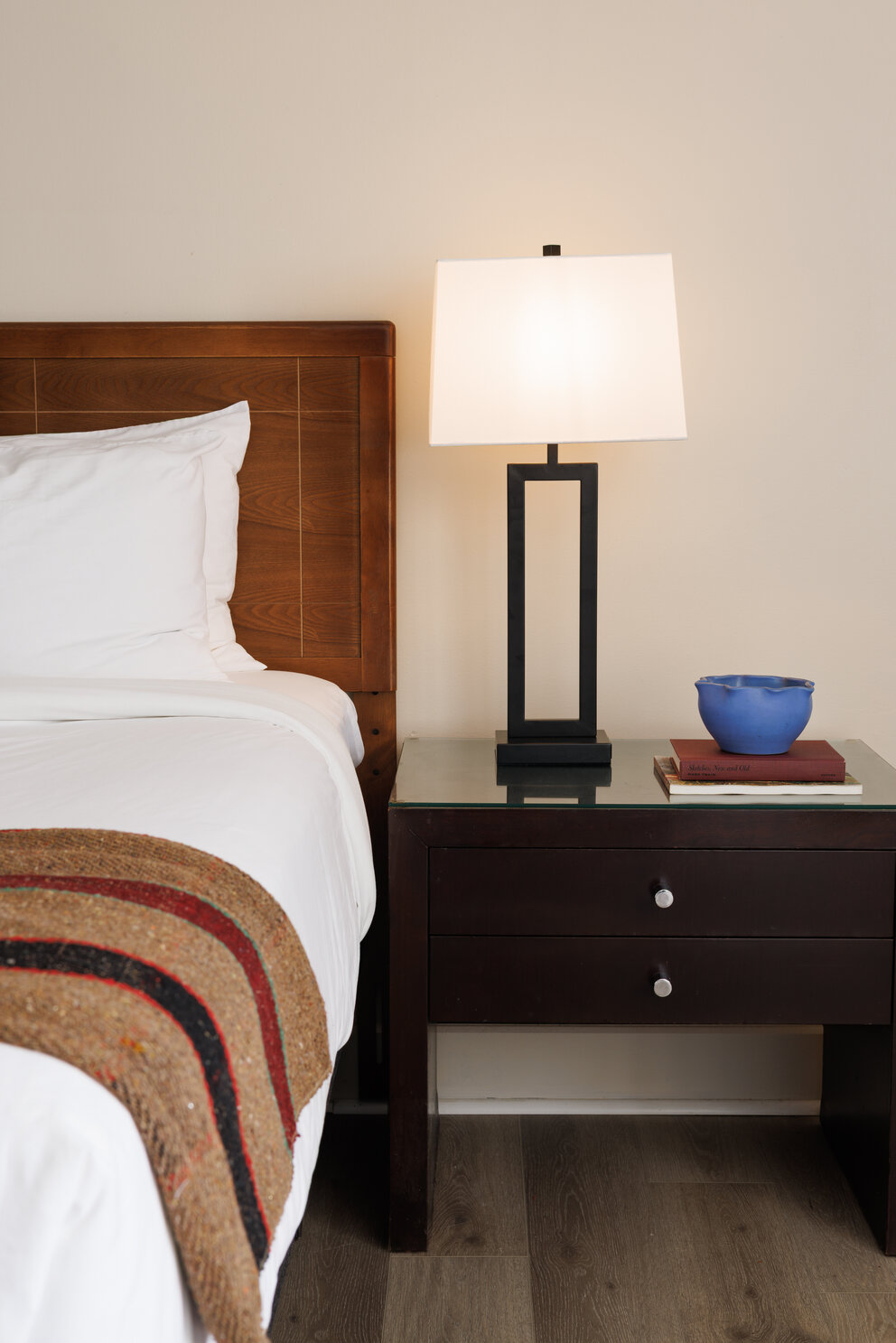 a lamp on a table next to a bed