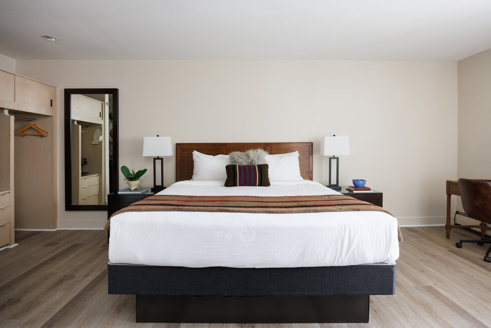 a bed with a wood headboard and a lamp