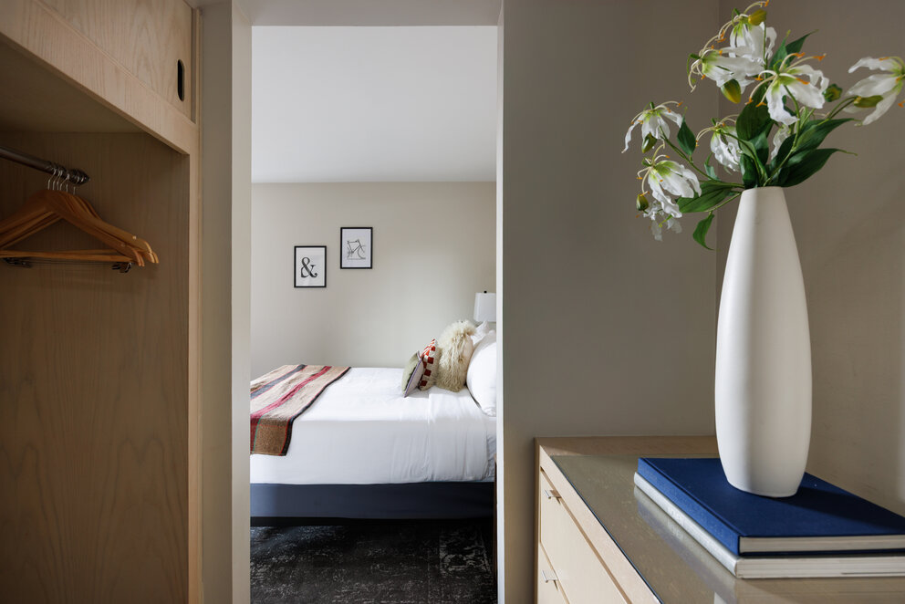 a white vase with flowers in a room