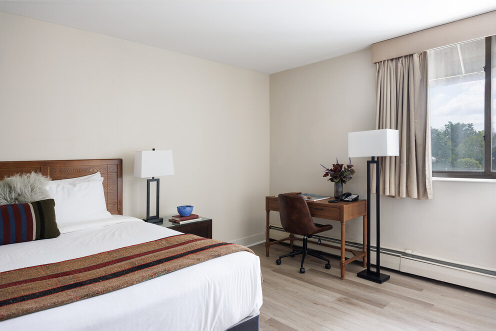 a bedroom with a desk and a lamp