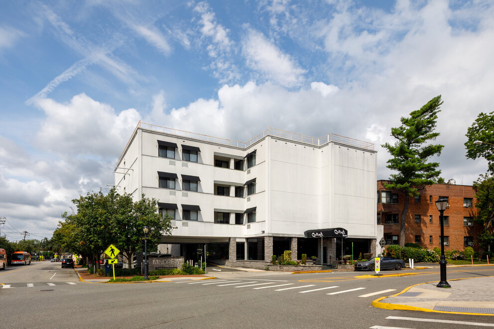 a building with a parking lot and trees