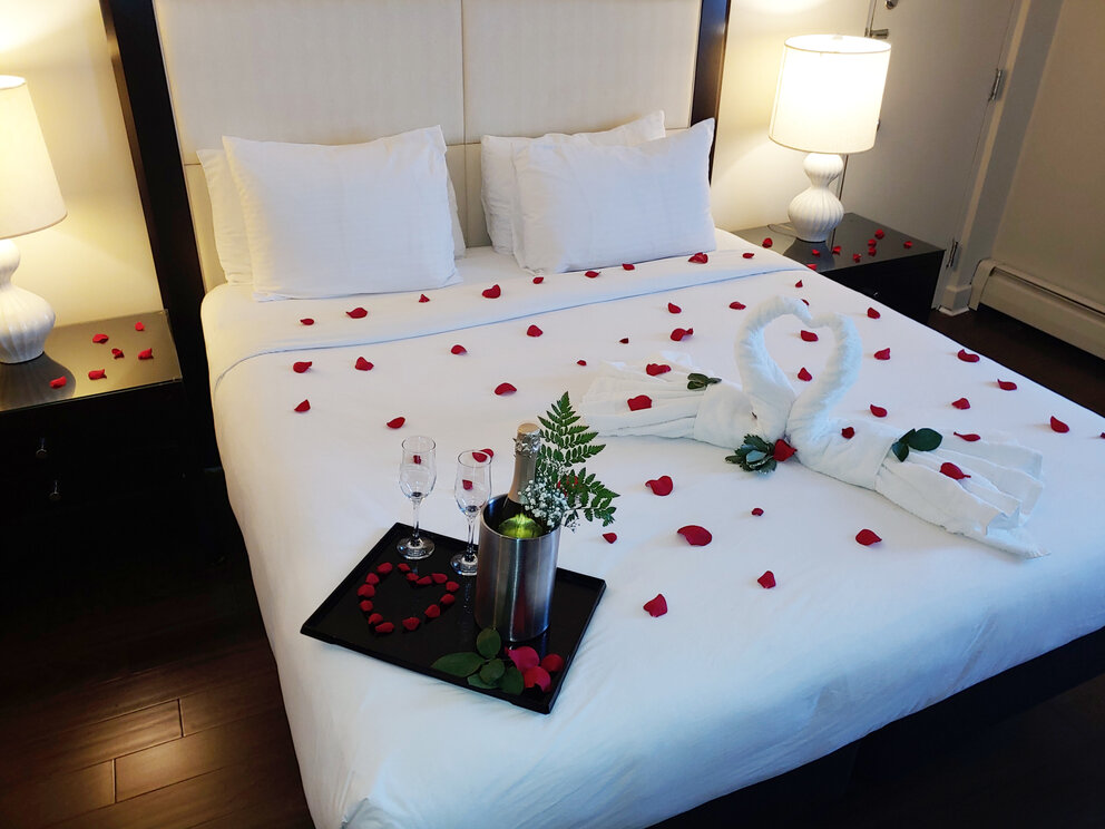 a room with bed and rose petals