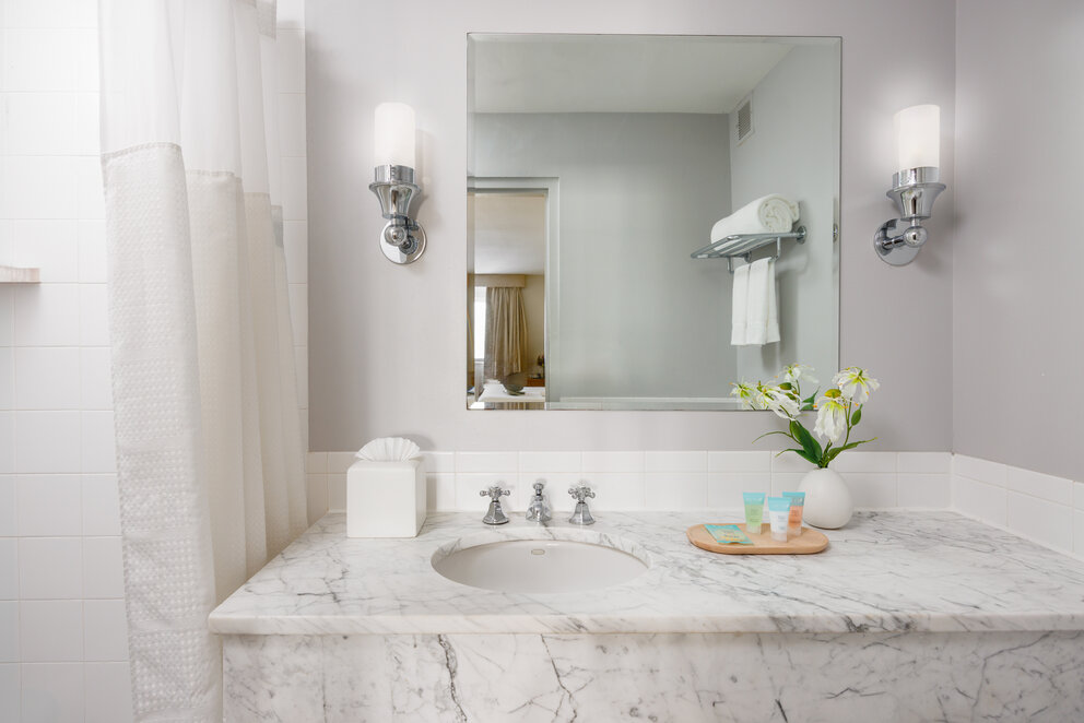 a bathroom with a marble countertop and a mirror