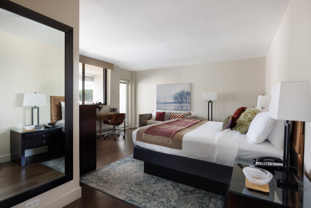 a bedroom with a large mirror and a bed