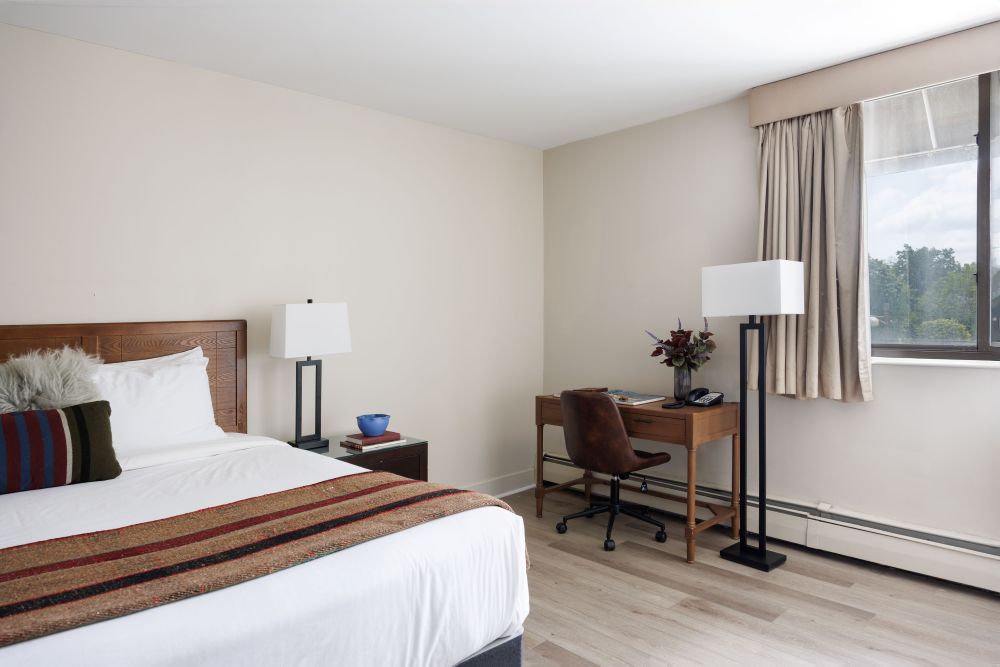 a bedroom with a desk and a lamp